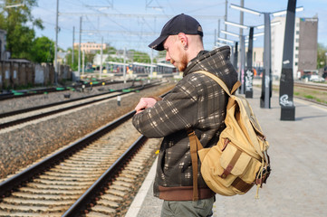 Young man waits train on railway station