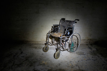 Gruseliger alter Rollstuhl im Keller - obrazy, fototapety, plakaty