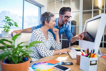 Obraz premium Casual businessman showing screen to his partner