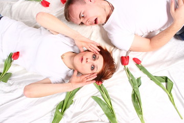 Obraz na płótnie Canvas happy couple in love on Tulip flowers