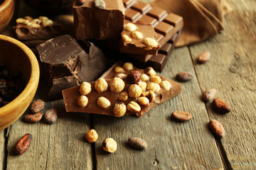 Still life with set of chocolate with nuts on wooden table, closeup