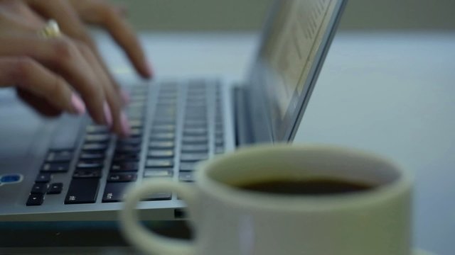 typing on a keyboard in a cafe, on a glass table with wiring
