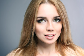 Fototapeta premium Young woman with long blonde hair and green eyes, natural beauty and skincare, youthful appearance and healthy lifestyle