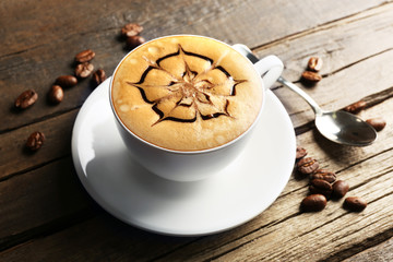 Cup of coffee latte art with grains on wooden background
