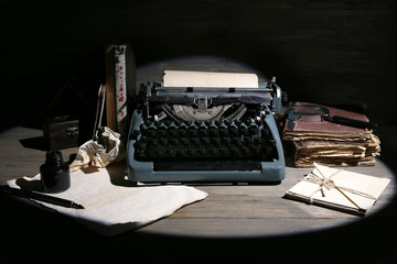 Retro typewriter in lamplight on wooden background