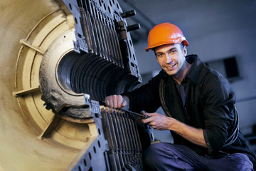 Portrait worker repairs powerful steam turbine. Work the factory