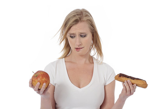 femme hésitant entre pomme et pâtisserie