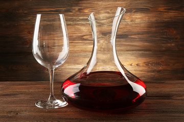 Glass carafe of wine on wooden background