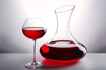 Glass carafe of wine on light background