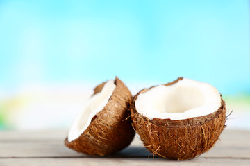 Coconut on wooden table on bright blurred background