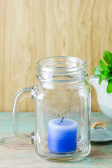 Obraz na płótnie Canvas Blue candle in bottle glass