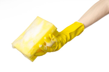 Hand holding a yellow sponge wet with foam  in studio gloves