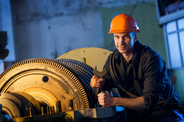 Portrait of worker repairs powerful steam turbine. Work Industry
