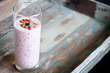 Healthy smoothie made from blended pineapple and kefir yogurt topped with pumpkin seeds, goji...