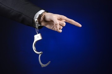 businessman in a black suit with handcuffs on his hands studio