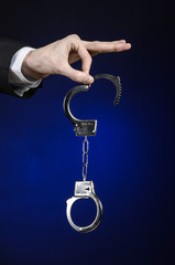 businessman in a black suit with handcuffs on his hands studio