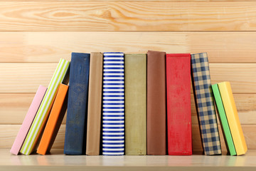 Books on shelf, close-up, on wooden background
