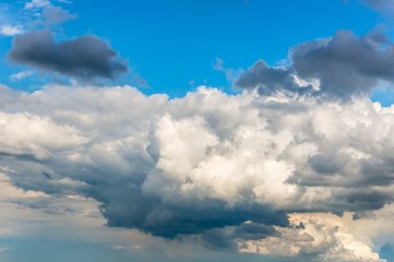 Blue sky background with white and dark clouds