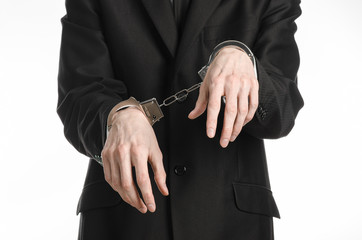businessman in a black suit with handcuffs on his hands studio