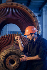 Portrait of a worker repairs powerful steam nuclear turbine.