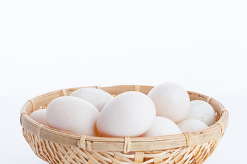 Raw dirty duck eggs in the bamboo bowl basket on white backgroun