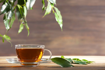 Cup of green tea on table on wooden background