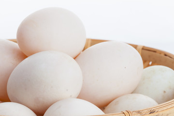 Raw dirty duck eggs in the bamboo bowl basket on white backgroun