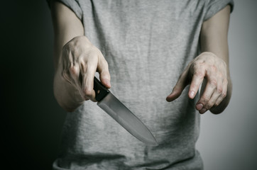 a man holding a knife on a gray background studio