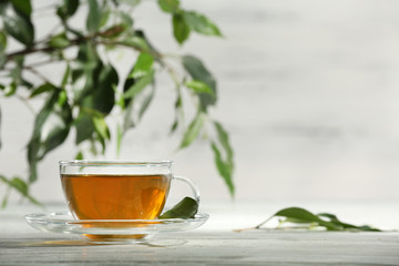 Cup of green tea on table on wooden background