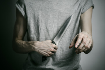 a man holding a knife on a gray background studio