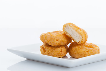 Group of fried chicken nuggets on white dish