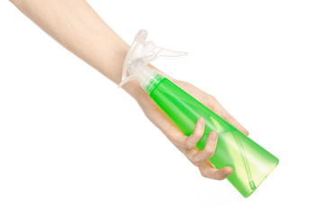 man's hand holding a green spray bottle for cleaning