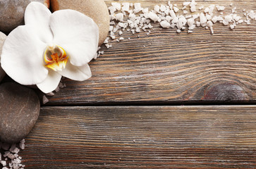 Fototapeta na wymiar Spa stones and orchid flower on wooden background