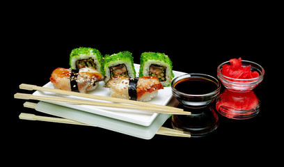 sushi and rolls on a plate on a black background