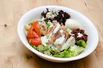 Grilled chicken salad with tomato, potato, onion