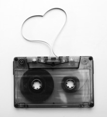 Audio cassette with magnetic tape in shape of heart isolated on white