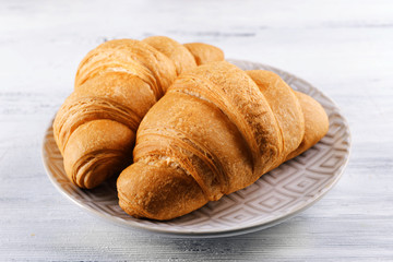 Delicious croissants on plate on table close-up