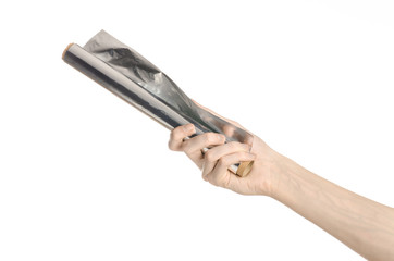 human hand holding a roll of foil on a white background