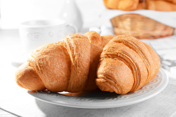 Delicious croissants on plate on table close-up