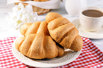 Delicious croissants on plate on table close-up
