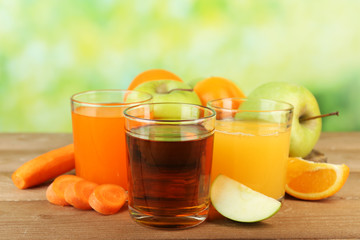 Assortment of healthy fresh juices on wooden table, on bright background