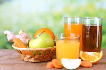 Assortment of healthy fresh juices on wooden table, on bright background
