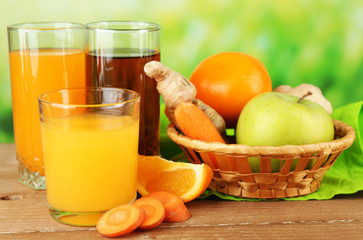 Assortment of healthy fresh juices on wooden table, on bright background