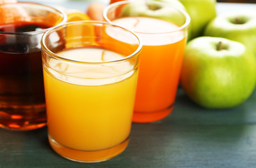 Assortment of healthy fresh juices and fruits on wooden table background