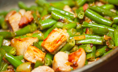 Cooking meat with green beans in fried pan