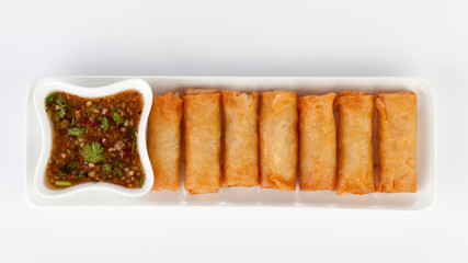crispy spring rolls on white dish with Sweet & Sour Sauce.