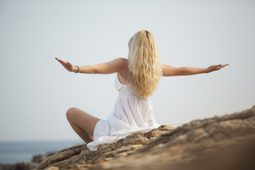 Fototapeta na wymiar woman meditating and relaxing on beach