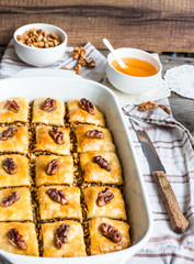 Turkish homemade baklava with honey and walnuts in a white bowl
