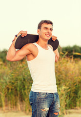 smiling teenage boy with skateboard outdoors © Syda Productions