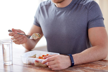 close up of man with fork and water eating food